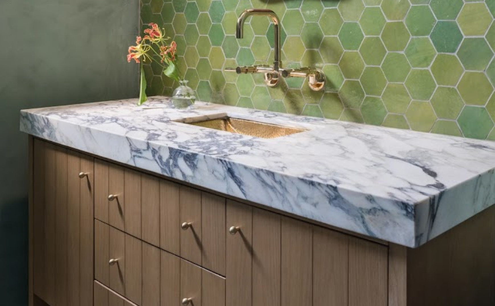 - Oasis Builders, Inc. Marble vanity with green hex tile backsplash