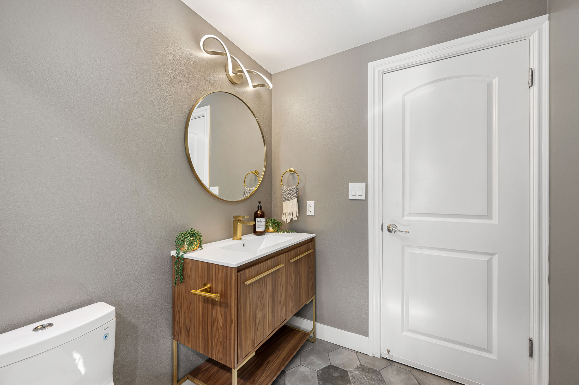- Oasis Builders, Inc. Powder Room Remodel with Walnut Vanity and Hex Tile Flooring